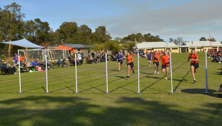 Students running a race on the oval at the athletics carnival