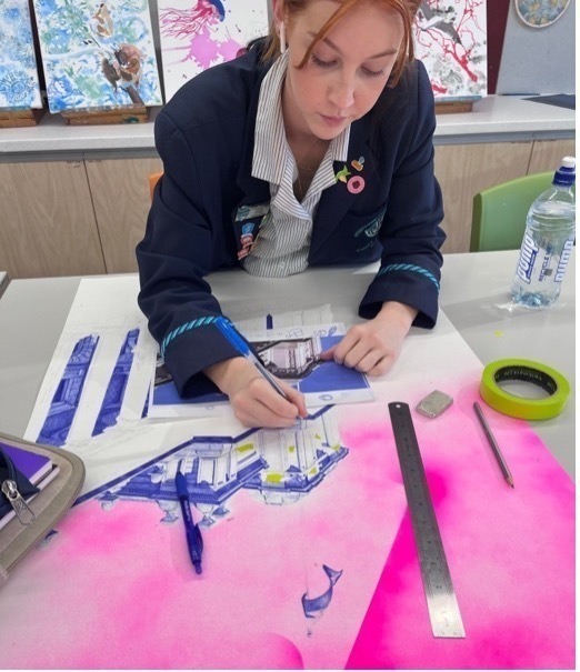 Student painting at a desk in visual art