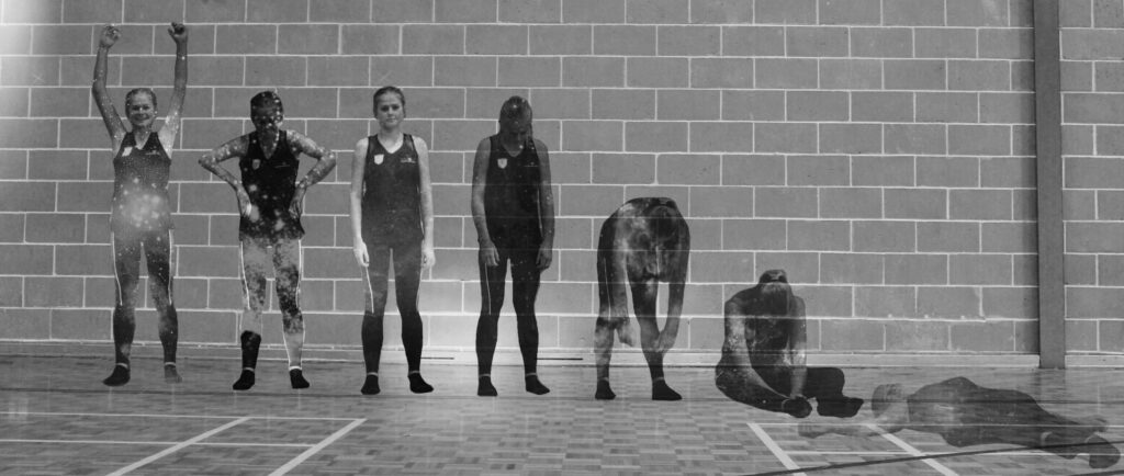 Black-and-white photo of students posing against a brick wall