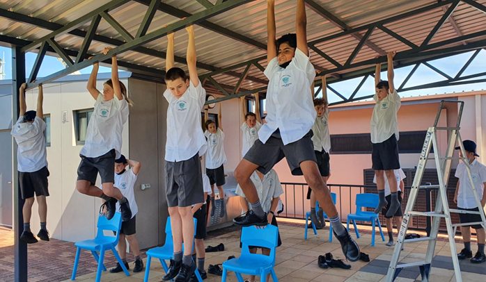 Students hanging from bars during the hang challenge