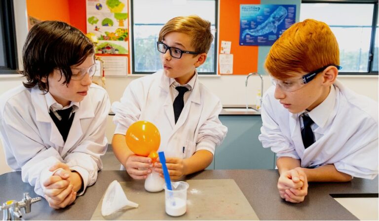 Students in lab coats conducting a science experiment