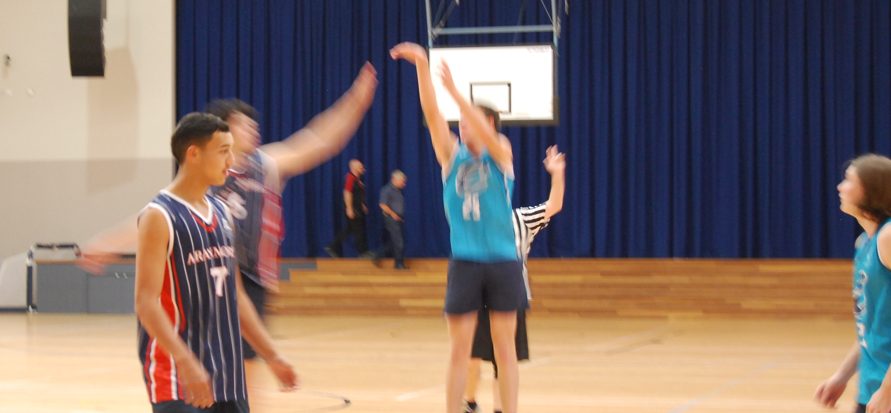 Students playing basketball in the school gym